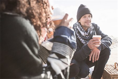 picnic not kids not mature - Young adult friends crouching on beach with takeaway coffee, Western Cape, South Africa Stock Photo - Premium Royalty-Free, Code: 649-08840222