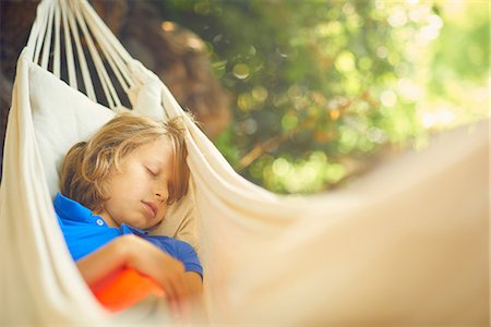 Cute boy reclining in garden hammock asleep Foto de stock - Sin royalties Premium, Código: 649-08840349