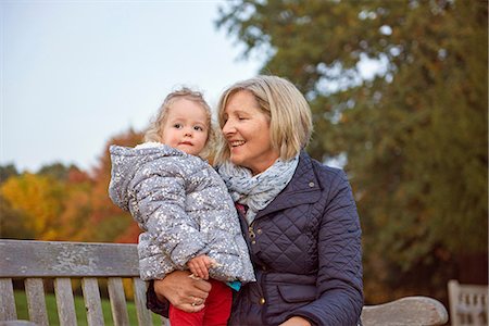 padded jacket - Senior woman sitting with toddler granddaughter in autumn park Stock Photo - Premium Royalty-Free, Code: 649-08840450