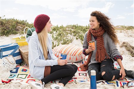 female jeans sitting - Two young women chatting beach picnic, Western Cape, South Africa Photographie de stock - Premium Libres de Droits, Code: 649-08840649