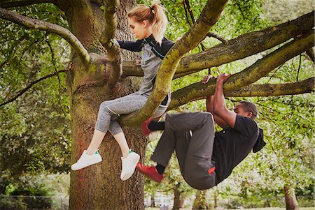 Personal trainer and young woman climbing up park tree Stock Photo - Premium Royalty-Free, Code: 649-08840694