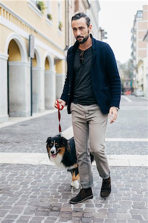 simsearch:649-08840788,k - Mid adult man walking his dog in cobbled city street Foto de stock - Sin royalties Premium, Código: 649-08840784