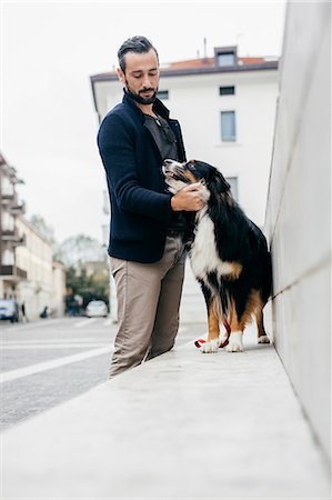 simsearch:649-08840788,k - Mid adult man petting dog on wall in city Foto de stock - Sin royalties Premium, Código: 649-08840798