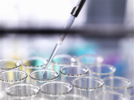 Sample being pipetted into a rack of test tubes inside a fume cupboard during a scientific experiment in a laboratory Photographie de stock - Premium Libres de Droits, Code: 649-08859488