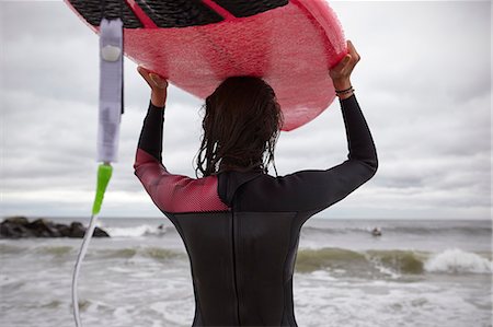 simsearch:649-02054536,k - Rear view of female surfer carrying surfboard on head at Rockaway Beach, New York, USA Stock Photo - Premium Royalty-Free, Code: 649-08859577