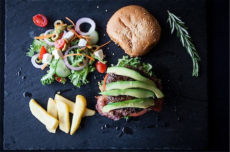 salat - Overhead view of hamburger with avocado, side salad and chips on slate Stockbilder - Premium RF Lizenzfrei, Bildnummer: 649-08859793