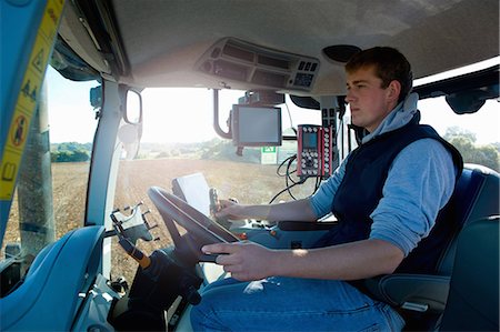 Young man driving tractor using global positioning system Foto de stock - Sin royalties Premium, Código: 649-08860045