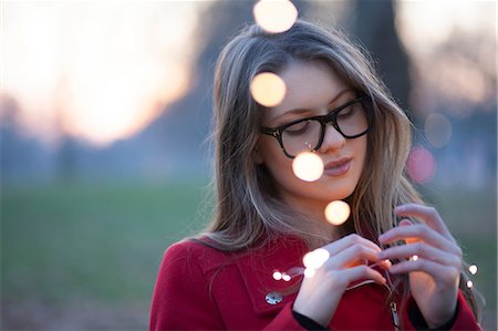 Young woman in park looking at lights in her hand, London, UK Photographie de stock - Premium Libres de Droits, Code: 649-08860122