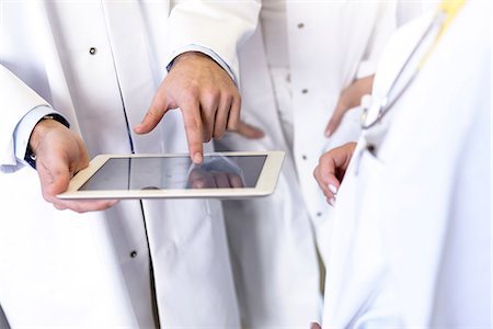 simsearch:649-09257295,k - Mid section of male and female doctors using digital pad touchscreen in hospital Fotografie stock - Premium Royalty-Free, Codice: 649-08860187