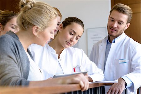 Male and female doctors looking at medical records on hospital balcony Photographie de stock - Premium Libres de Droits, Code: 649-08860197