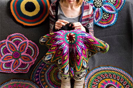 Cropped view of woman sitting on floor crocheting, surrounded by crochet circles Photographie de stock - Premium Libres de Droits, Code: 649-08860221