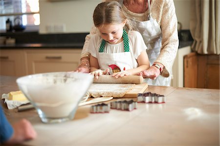 simsearch:649-08969050,k - Senior woman and granddaughter rolling dough for Christmas tree cookies Stock Photo - Premium Royalty-Free, Code: 649-08860515