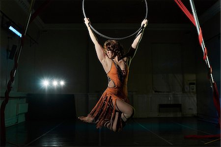 Young female acrobat poised hanging from hoop Stock Photo - Premium Royalty-Free, Code: 649-08860531