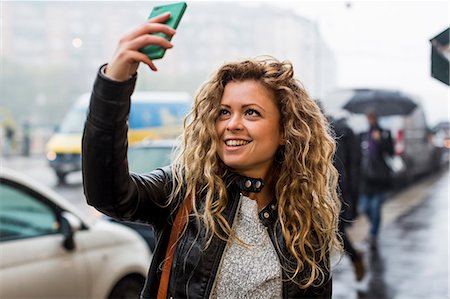 Woman in street taking selfie Stock Photo - Premium Royalty-Free, Code: 649-08894016