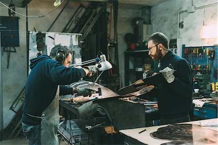 Male metalworkers hammering copper at forge workbench Foto de stock - Sin royalties Premium, Código: 649-08894127