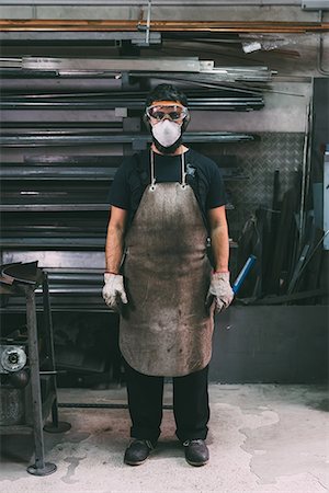 Portrait of male metalworker in dust mask, forge storeroom Foto de stock - Sin royalties Premium, Código: 649-08894129