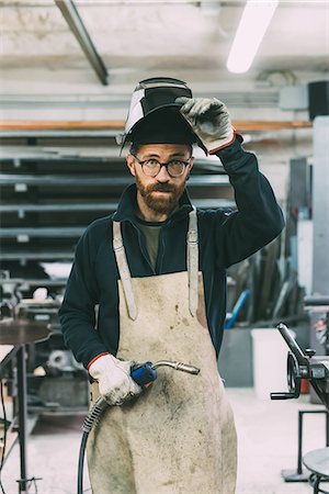 Portrait of metalworker holding welding torch in forge workshop Stock Photo - Premium Royalty-Free, Code: 649-08894139