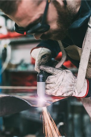 Metalworker cutting copper with welding torch in forge workshop Stock Photo - Premium Royalty-Free, Code: 649-08894148