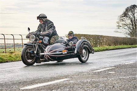 seniors motorcycle - Senior man and grandson riding motorcycle and sidecar along rural road Photographie de stock - Premium Libres de Droits, Code: 649-08894176