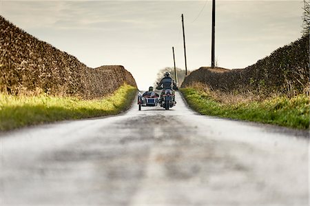 riding a man - Rear view of senior man and grandson riding motorcycle and sidecar on rural road Stock Photo - Premium Royalty-Free, Code: 649-08894172