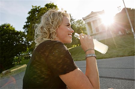 simsearch:649-06352541,k - Mid adult woman in sunlit park drinking lemonade Foto de stock - Royalty Free Premium, Número: 649-08894250