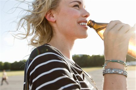 simsearch:841-03063077,k - Mid adult woman drinking bottled beer outdoors Photographie de stock - Premium Libres de Droits, Code: 649-08894261