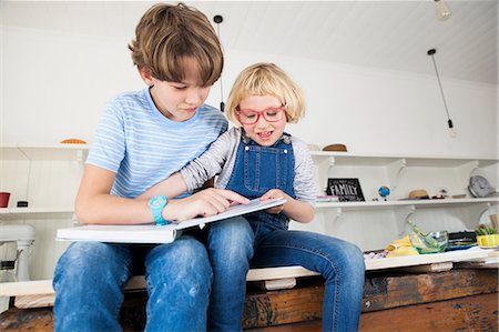 Girl grabbing storybook from brother on kitchen counter Foto de stock - Sin royalties Premium, Código: 649-08894301