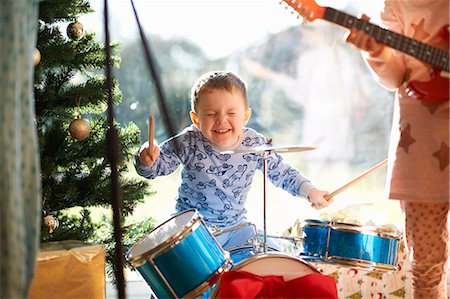 Boy and sister playing toy drum kit and guitar on christmas day Photographie de stock - Premium Libres de Droits, Code: 649-08894379
