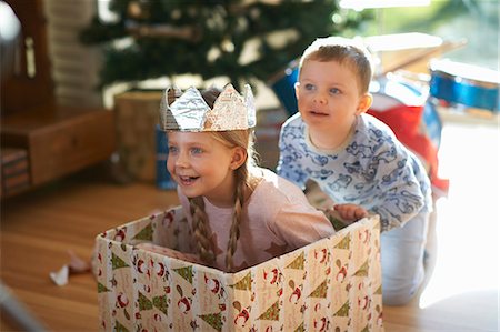 Boy pushing sister in cardboard box at christmas Stock Photo - Premium Royalty-Free, Code: 649-08894371