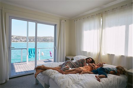 simsearch:649-08894469,k - Mother and children sleeping on bed in houseboat, Kraalbaai, South Africa Fotografie stock - Premium Royalty-Free, Codice: 649-08894485