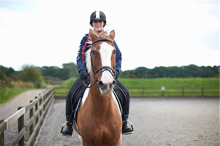 Young woman riding horse around paddock Foto de stock - Sin royalties Premium, Código: 649-08894577