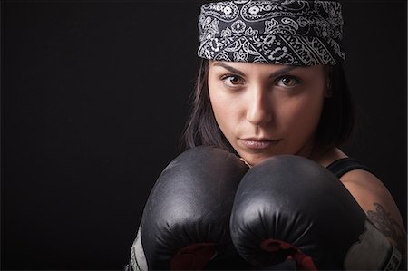 Portrait of young woman wearing boxing gloves, in fighting stance Foto de stock - Sin royalties Premium, Código: 649-08894591