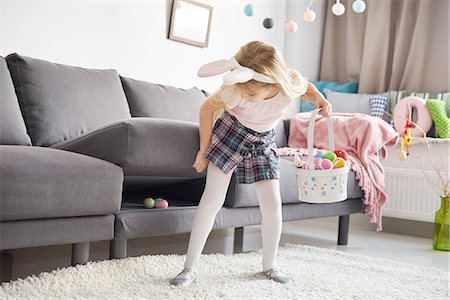 Girl finding easter eggs under sofa cushion Foto de stock - Sin royalties Premium, Código: 649-08894616