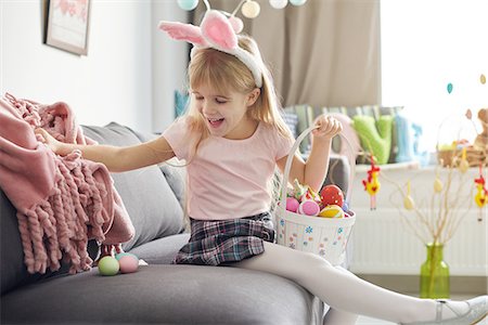 skirt girl child - Girl finding easter eggs under sofa blanket Stock Photo - Premium Royalty-Free, Code: 649-08894617