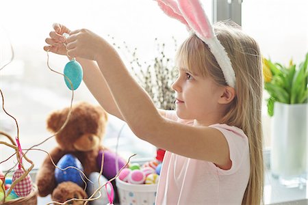 simsearch:700-01124525,k - Girl in bunny ears making easter egg decoration in living room Photographie de stock - Premium Libres de Droits, Code: 649-08894619