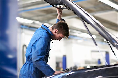 simsearch:649-07803896,k - College mechanic student inspecting under car hood in repair garage Foto de stock - Sin royalties Premium, Código: 649-08894627