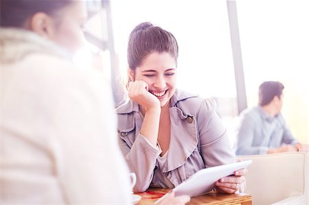 simsearch:649-08923947,k - Two businesswomen looking at digital tablet during meeting in cafe Foto de stock - Sin royalties Premium, Código: 649-08894711