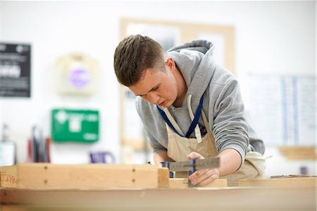 simsearch:649-08894629,k - Male teenage carpentry student adjusting wood clamp in college workshop Photographie de stock - Premium Libres de Droits, Code: 649-08894752