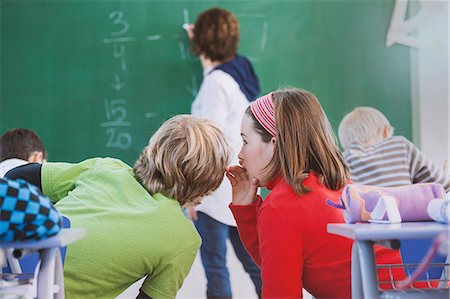 picture cheating school - Teacher writing on blackboard, two students whispering to each other behind her Stock Photo - Premium Royalty-Free, Code: 649-08894798