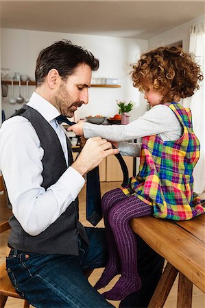 family with one child - Girl tying father's tie in kitchen Stock Photo - Premium Royalty-Free, Code: 649-08894924