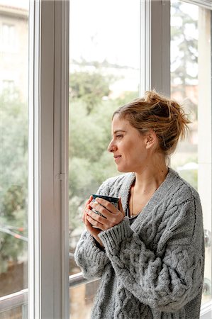 simsearch:649-09123654,k - Woman at home, looking out of window, holding hot drink Photographie de stock - Premium Libres de Droits, Code: 649-08895032