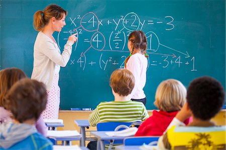 Primary school teacher explaining equation on classroom blackboard Stock Photo - Premium Royalty-Free, Code: 649-08895122