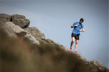 Male runner looking at smartwatch on Stanage Edge, Peak District, Derbyshire, UK Foto de stock - Sin royalties Premium, Código: 649-08895173