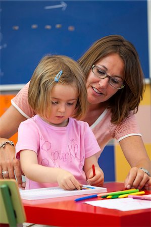 Preschool girl and teacher with colouring pens in classroom Photographie de stock - Premium Libres de Droits, Code: 649-08895188