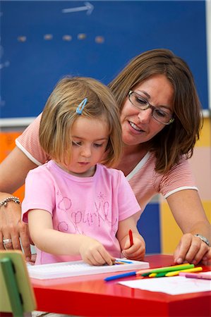 simsearch:6122-08212585,k - Preschool girl and teacher with colouring pens in classroom Foto de stock - Sin royalties Premium, Código: 649-08895188