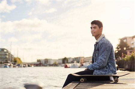 simsearch:649-09249868,k - Young man sitting by river, skateboard beside him, Bristol, UK Foto de stock - Royalty Free Premium, Número: 649-08900469