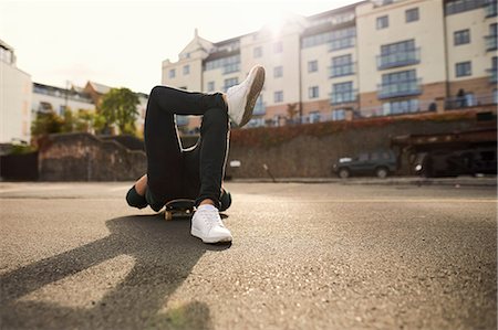 Young man laying on skateboard, relaxing, Bristol, UK Fotografie stock - Premium Royalty-Free, Codice: 649-08900479