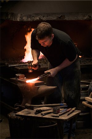 Farrier forging horseshoe on anvil Foto de stock - Sin royalties Premium, Código: 649-08900540