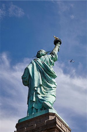 simsearch:649-08900707,k - Low angle view of Statue of Liberty and airplane in blue sky, New York city, USA Foto de stock - Sin royalties Premium, Código: 649-08900704