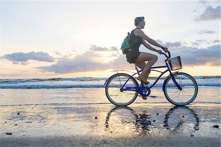 Woman cycling on beach at sunset, Nosara, Guanacaste Province, Costa Rica Foto de stock - Sin royalties Premium, Código: 649-08900717
